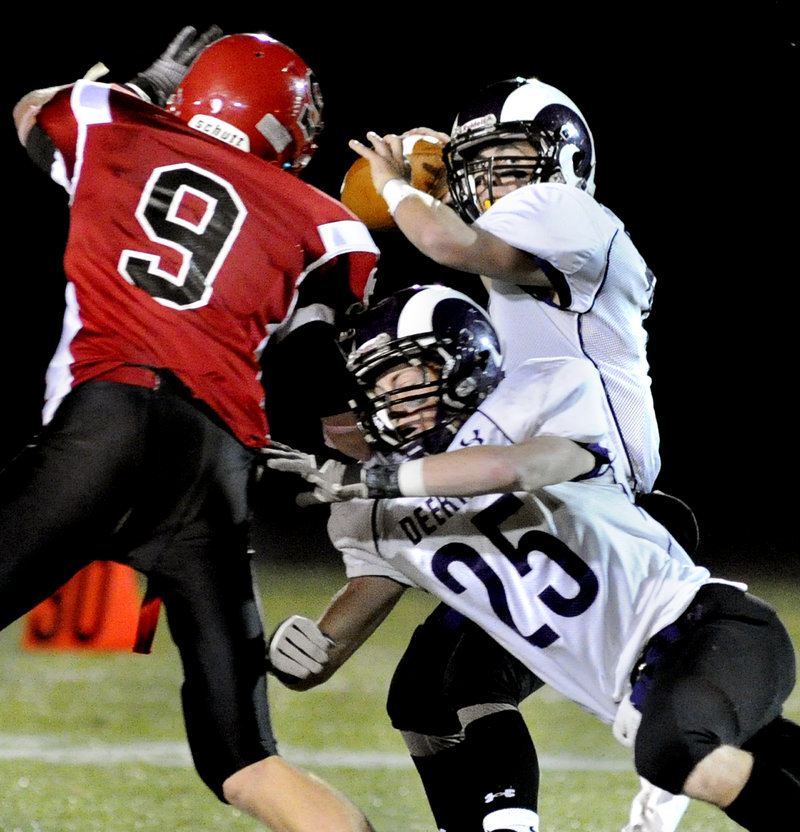 Deering quarterback Matt Flaherty picks out a receiver Thursday night as Trey Thomes springs a block on Kolbey Adams of Scarborough during their Western Class A game at Scarborough High. Deering earned a 14-7 victory.