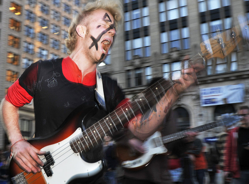 Travis Mencher, the bass player for Portland-based Butcher Boy, jams with the band in Monument Square during the First Friday Art Walk. Butcher Boy’s performance supported Occupy Maine, the ongoing protest against corporate greed that has set up a tent village in Lincoln Park as an offshoot of the Occupy Wall Street movement in Manhattan. As a result, protesters, paraders and art enthusiasts filled the city’s streets Friday night.