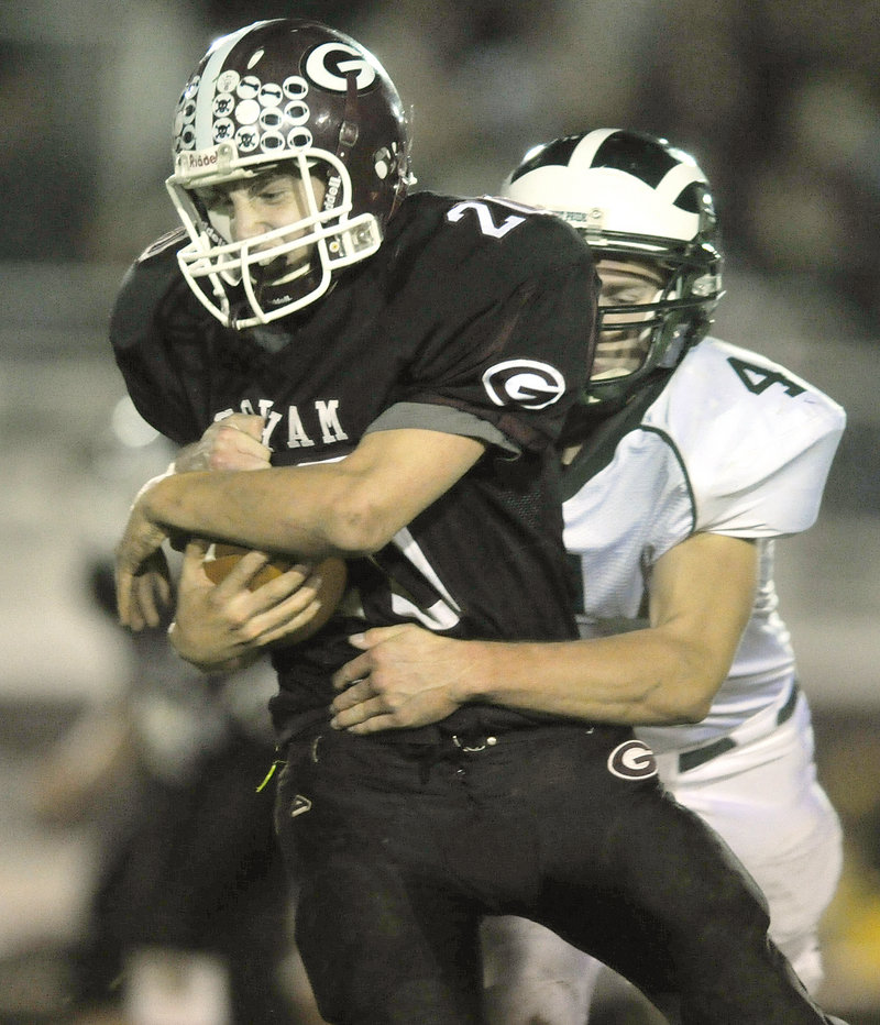 Jon Woods of Gorham protects the ball while being tackled by Tyson Goodale of Bonny Eagle following a short gain.