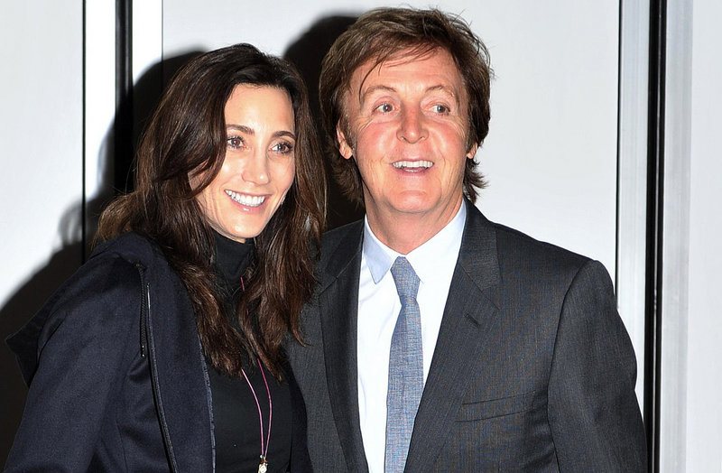 Paul McCartney and his fiancee, Nancy Shevell, pose for photographers outside their home in north London on Saturday.