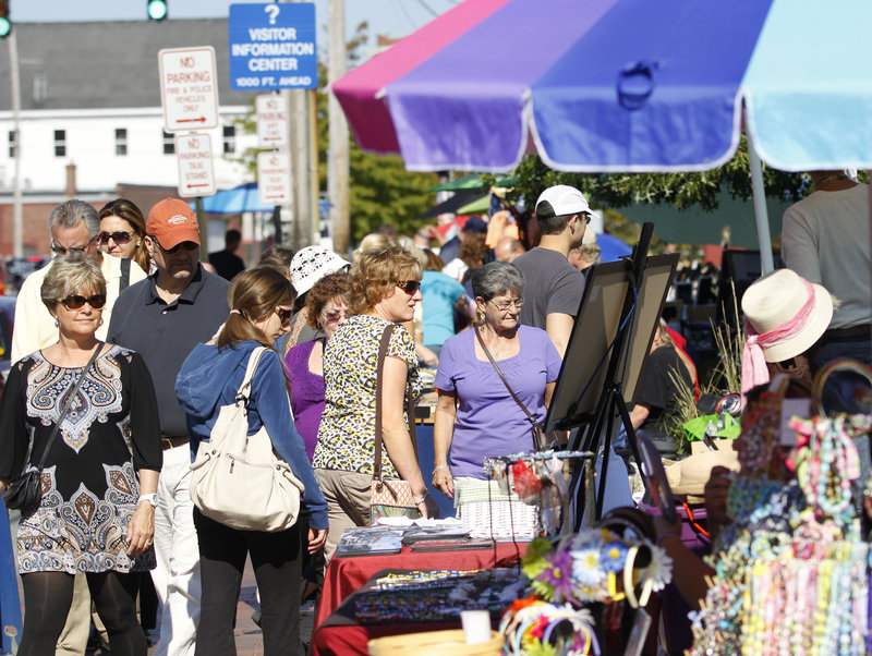 Shoppers browse the artisans' booths at Bell Buoy Park near the ferry terminal in Portland on Saturday, as 2,250 passengers from a visiting cruise ship converged on the city. The vendors create a lively atmosphere for cruise arrivals.