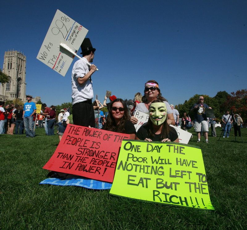 Tamra Bell, 52, back right, and her four children, Stephanie Stayton, 28, left front, Robert, 21, left back, and Courtney, 23, attend the Occupy Indy protest in Indianapolis on Saturday. Tamra's husband has been unemployed for two years and suffers from health problems. Robert's small income has helped the family to stay in its home so far.