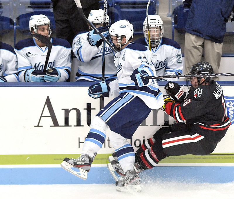 Maine’s Spencer Abbott stays standing after checking Northeastern’s Mike McLaughlin into the boards during the Black Bears’ 6-3 win over the Huskies. Maine pelted the Northeastern net with 40 shots on goal.