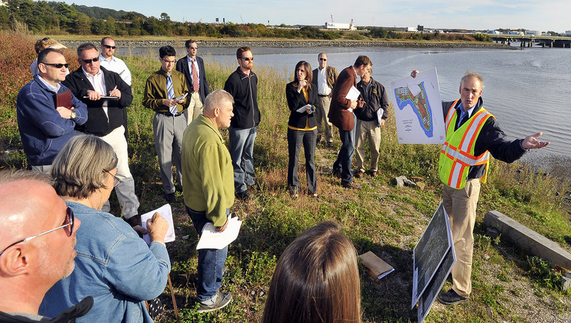 Standing at the tip of Thompson's Point, Steve Bushey, right, Senior Engineer with DeLuca-Hoffman Associates, Inc., explains many of the features of the development plan to a group of media, planning board members, developers and other interested individuals during a tour of the Forefront development on Thompson's Point.