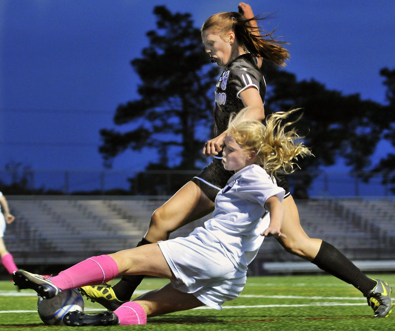 Meaghan Wells of Deering slides to try and keep the ball away from Abby Hyson of Marshwood during their Western Class A girls’ soccer game Tuesday night at Deering High. Deering earned a 3-0 victory.