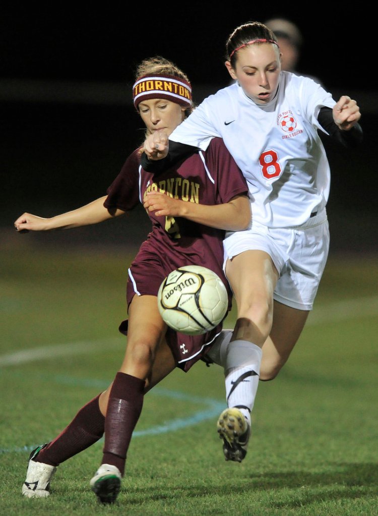 Jamie Durie of Thornton Academy, left, attempts to control the ball and hold off Clara Ellis of South Portland.