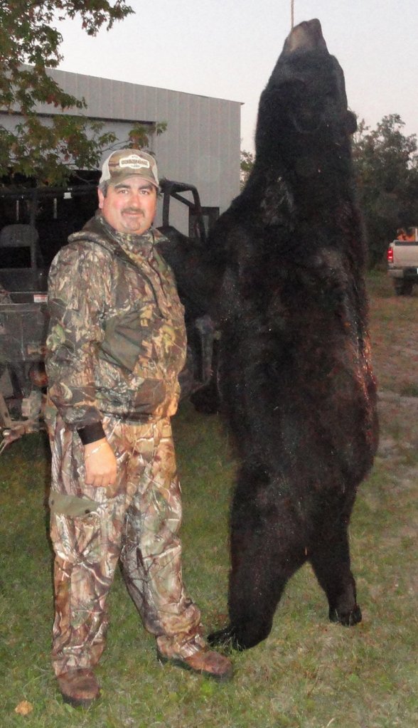 Tony Weber of North Dakota is dwarfed by the 7-foot bear he shot in September.