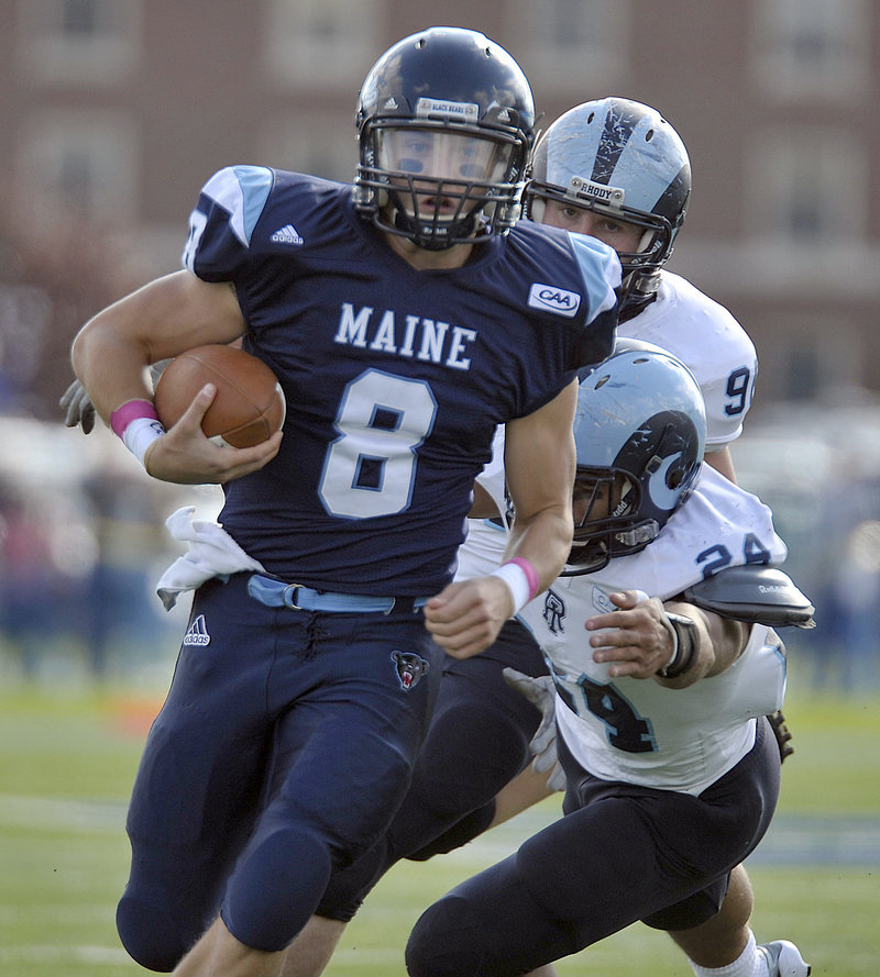 University of Maine quarterback Warren Smith scrambles away from Rhode Island’s Dave Zocco (24) and James Timmins during Saturday’s game at Orono. Smith threw three touchdown passes to help the Black Bears build a 27-7 lead on the way to a 27-21 Colonial Athletic Association victory.