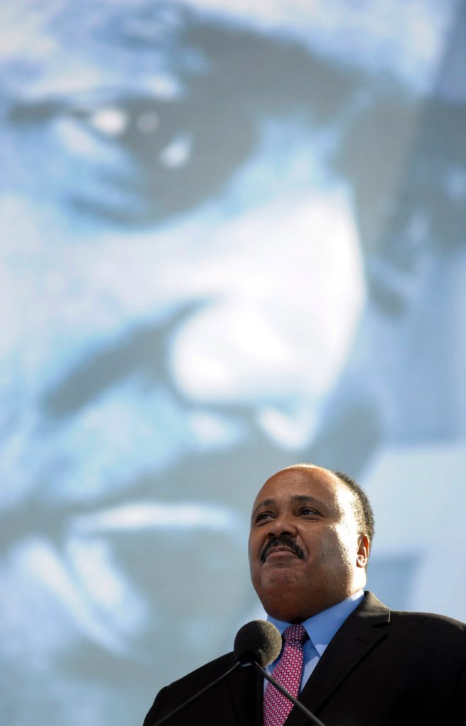Standing beneath an image of Martin Luther King Jr., Martin Luther King III speaks at the dedication of his father’s memorial in Washington on Sunday.