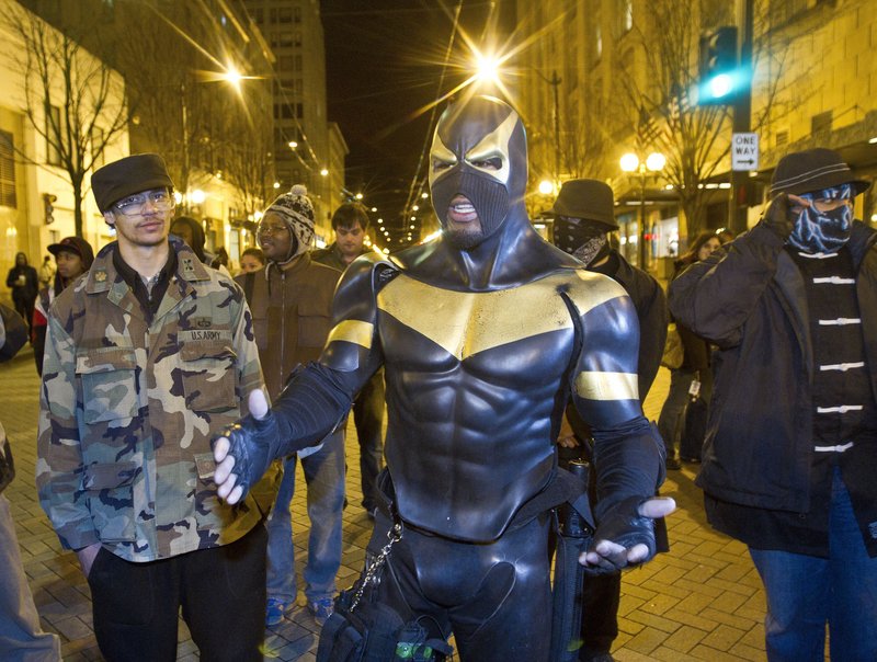 Self-described superhero Phoenix Jones meets with protesters at a Seattle park last February during a rally against police brutality. Police arrested Jones, whose real name is Benjamin Fodor, earlier this month and are investigating whether he assaulted several people with pepper spray while trying to break up an alleged fight.