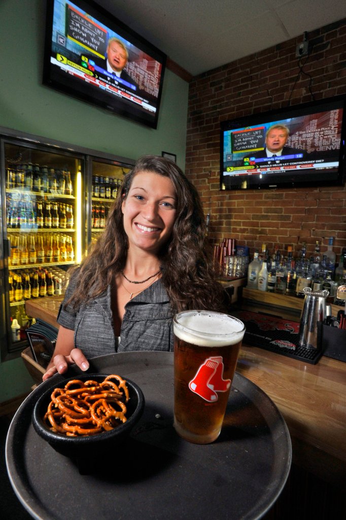 Thatcher’s bartender Tonia Pelletier serves a draft beer and snack of pretzels.
