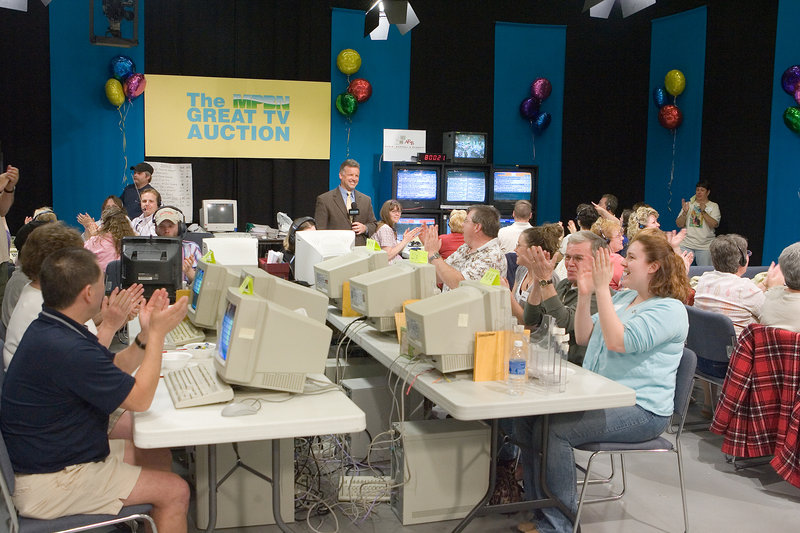 Volunteers and other workers cheer during The MPBN Great TV Auction. Network officials say the costs of the auction ate up about two-thirds of the event’s revenue and they are pursuing alternative fundraising methods.