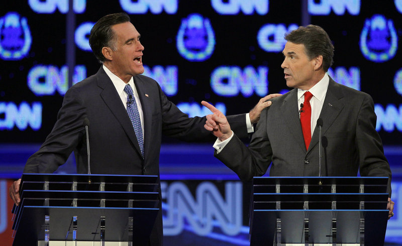 Former Massachusetts Gov. Mitt Romney, left, and Texas Gov. Rick Perry confront each other during the Republican presidential debate Tuesday in Las Vegas.