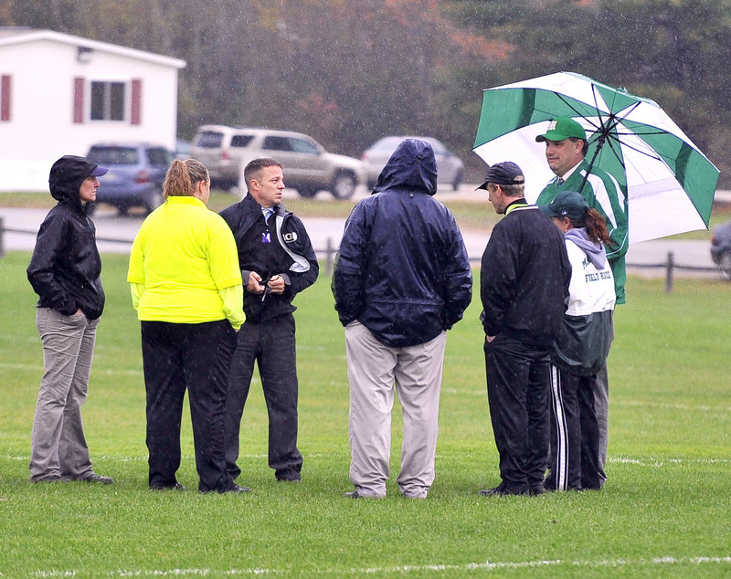 With rain coming down and a muddy area in front of one goal, officials make the wait-’til-tomorrow field hockey decision.