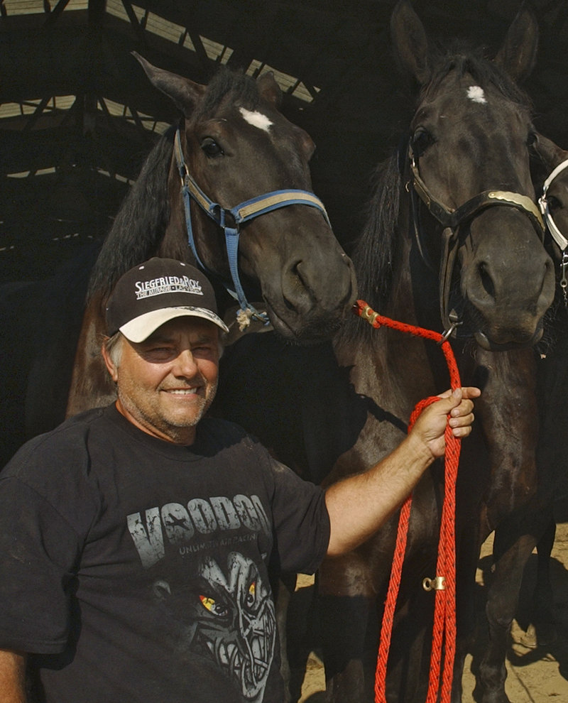 Terry Thompson stands with some of his award-winning Percheron horses on his farm west of Zanesville, Ohio.