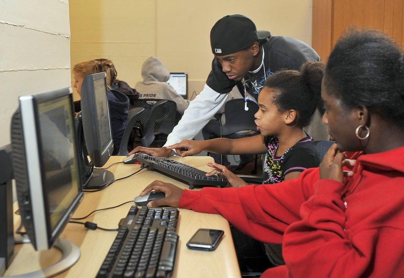 Shantel Anthony, 10, center, gets help from Mark Hughes, 15, as Dominique Anthony, 21, observes during a learning lab at the Mission Possible Teen Center on Thursday. More than 100 guests, not including the teens, attended the open house.