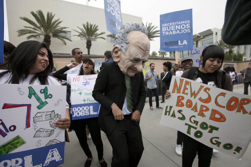 A protester dressed as News Corp. CEO Rupert Murdoch is seen with other demonstrators at Fox Studios in Los Angeles on Friday.
