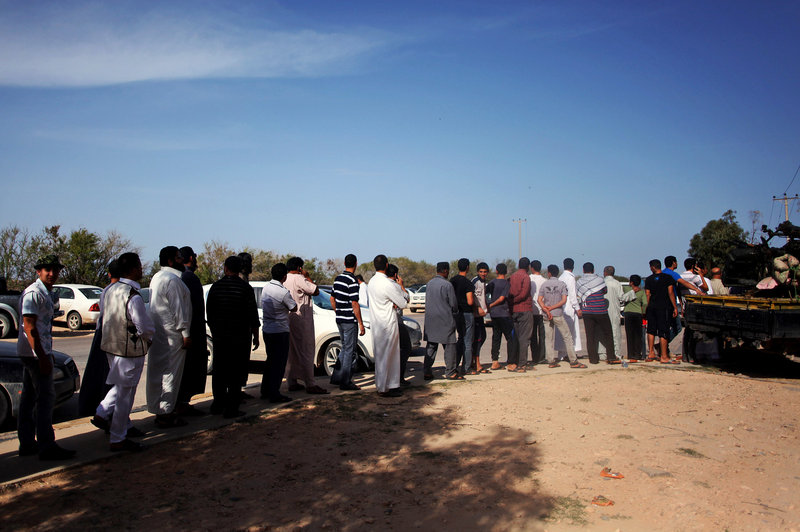 Libyans line up to view Moammar Gadhafi’s body in Misrata, Libya, on Friday. Burial has been delayed until circumstances of his death are further examined and a decision is made about where to bury the body.