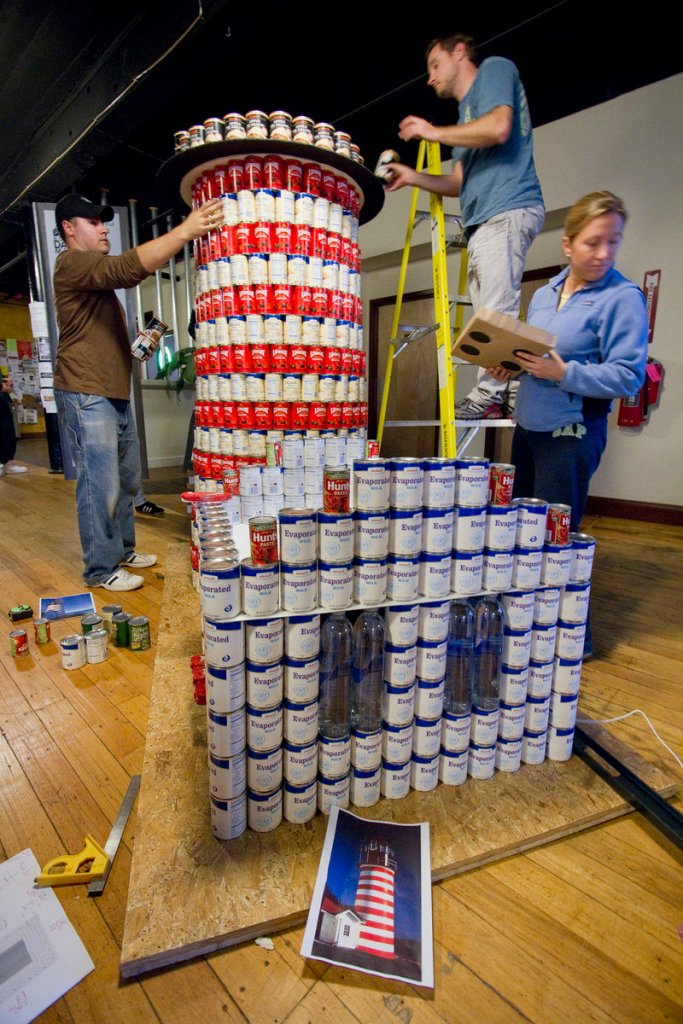 A team from Oak Point Associates of Biddeford builds a replica of West Quoddy Head Light out of cans during a Canstruction competition in Biddeford on Saturday. The team, working in the North Dam Mill, was one of five competing in three downtown locations. Food, provided by participants, will be donated to Friends of Community Action’s pantry.