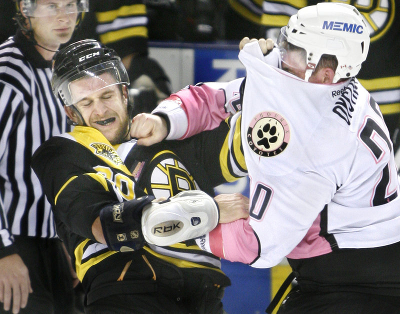 Nathan Oystrick of the Portland Pirates lands a punch on Lane MacDermid of the Providence Bruins despite having his jersey over his eyes. Providence won, 4-3.