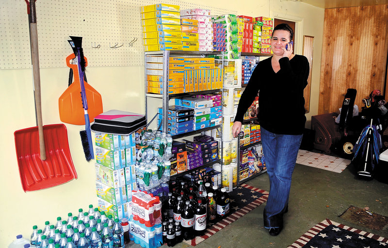 Amanda Fontaine takes a call Thursday in the garage of her Augusta home where she stores groceries. She and her friend Jen Barrows of Manchester call themselves the Coupon Chicks of Maine and have a Facebook page about local deals.
