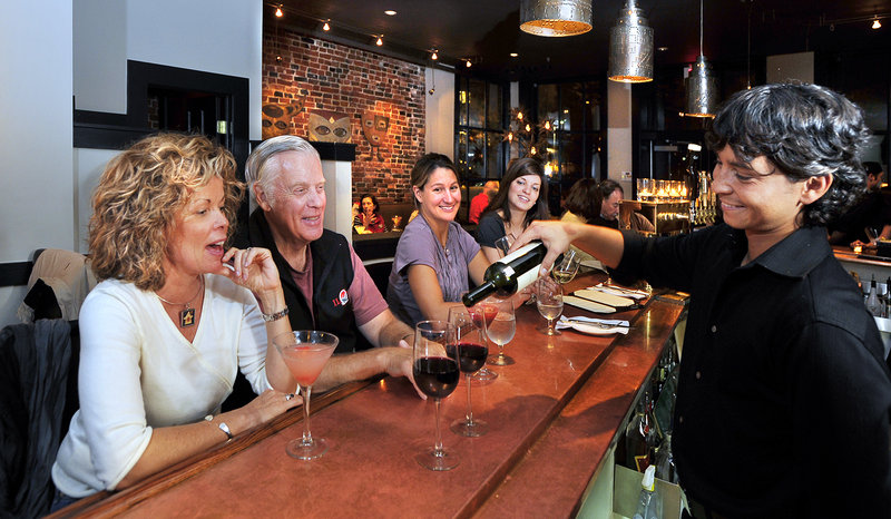 Bartender Amicis Arvizu pours a couple of glasses of Malbec wine as Carrie Ponte and John Galley, regular patrons of Zapoteca, savor their margaritas. Looking on are Tabitha Blake of Yarmouth and Carolyn Giles, far right, of Brunswick. Zapoteca specializes in authentic Mexican cuisine and libations.