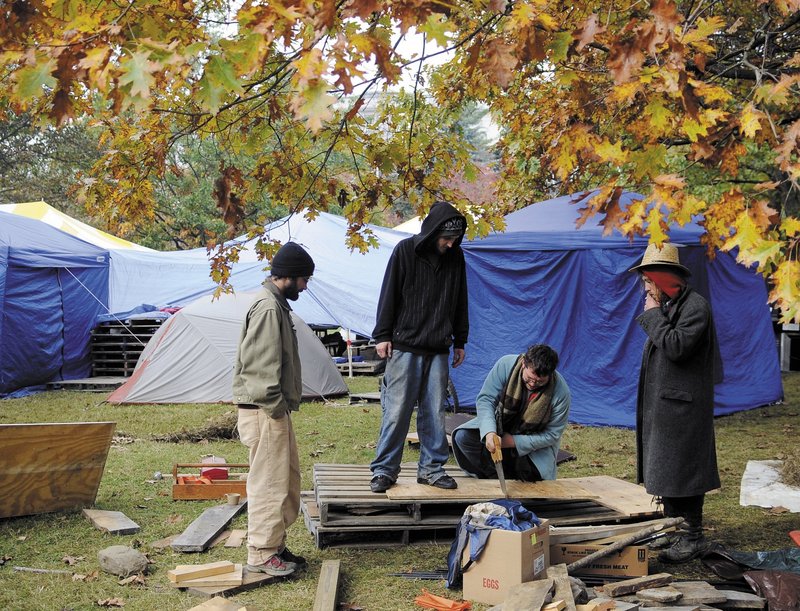 Protesters with Occupy Augusta saw wooden platforms for their tents Monday in Capitol Park. They said that the wood will prevent frost from heaving their tents, as the occupancy enters its second week. Some of them will be attending a forum on the campus green at the University of Maine at Augusta on Thursday afternoon.