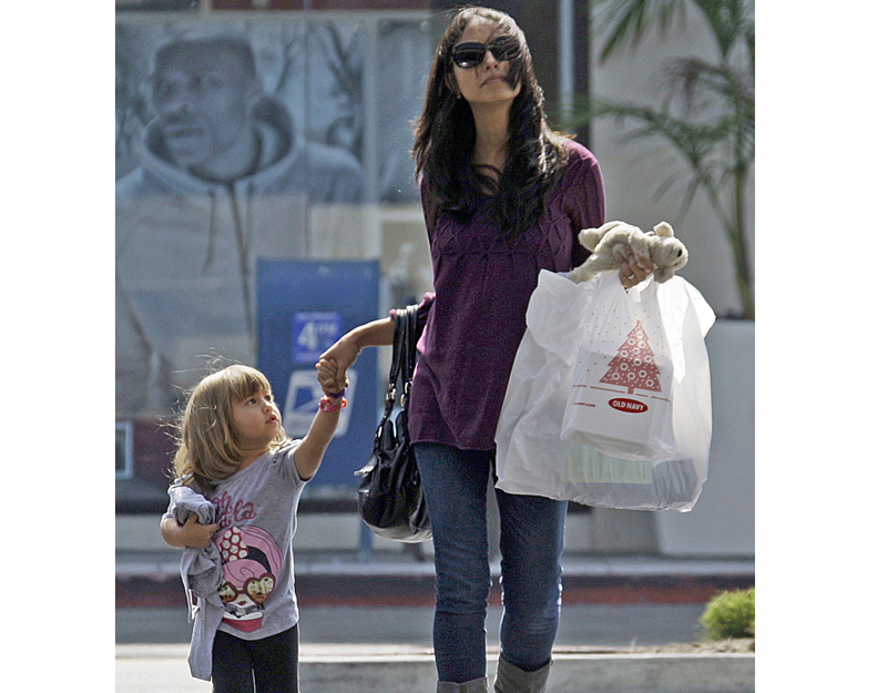 A woman and child leave a mall with purchases recently in Culver City, Calif. Economists say consumer confidence doesn't necessarily track with how they spend their money.