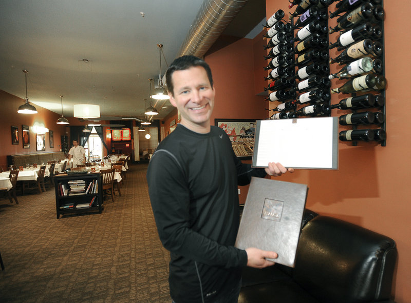 Owner Eric Agren holds a menu and the restaurant’s extensive international wine list at Fuel.