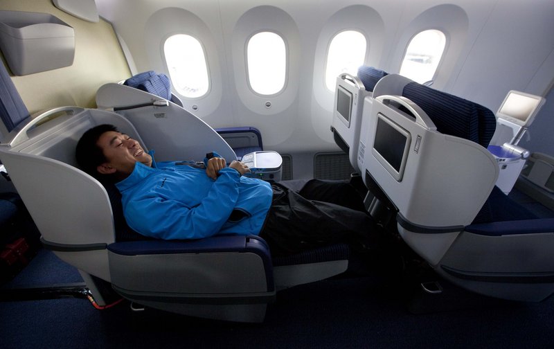 Kang Kang of China Central TV reclines aboard a new Boeing 787.