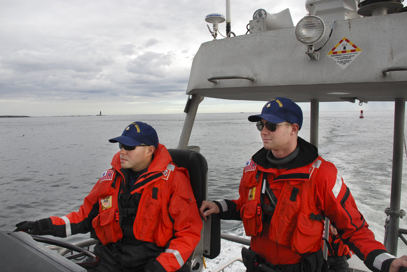 Boatswain’s Mates Second Class Ruben A. Colon, left, and Jon Gielarowski patrol Casco Bay on a 47-foot motor lifeboat out of South Portland on Oct. 22.