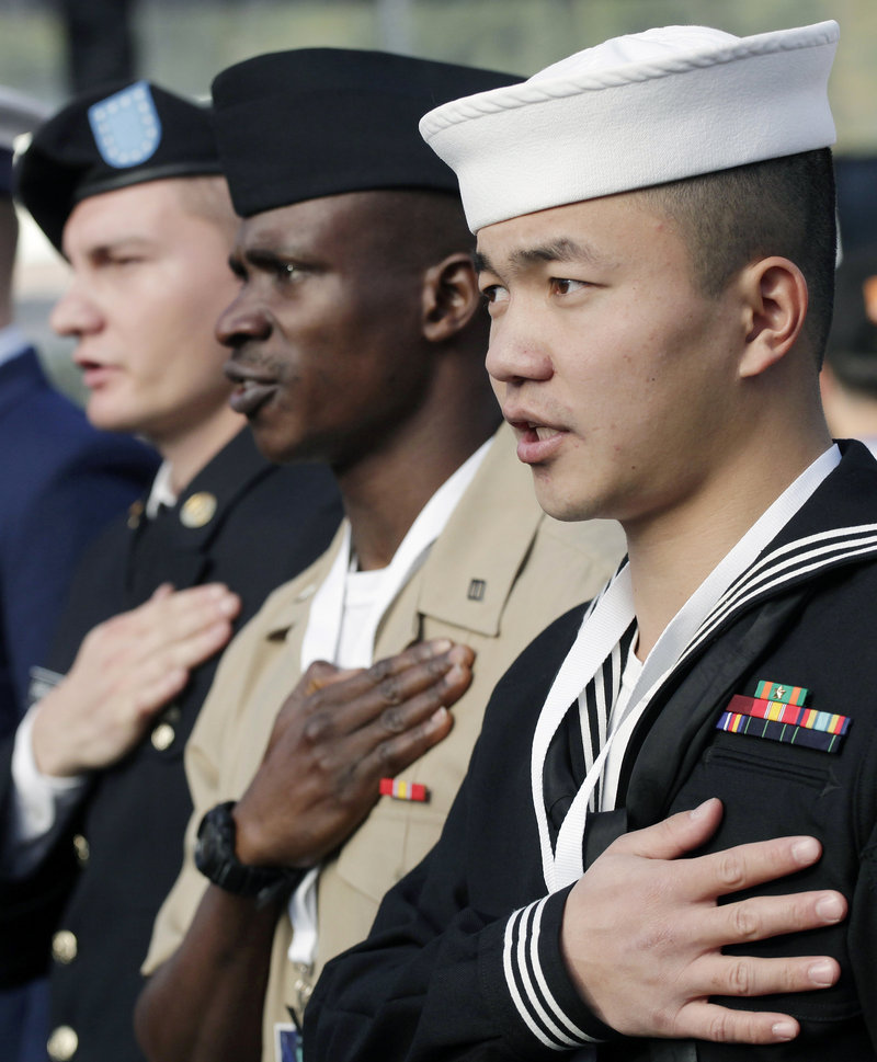 Zuyu Nu, right, who was born in China and serves in the U.S. Navy, takes the oath of citizenship, with 124 others from 46 countries, during a naturalization ceremony at the Statue of Liberty on Friday in New York.