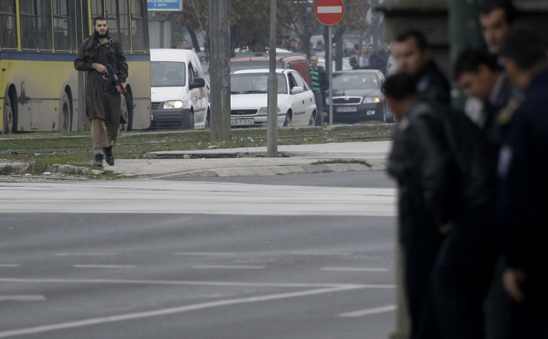 Gunman Mevlid Jasarevic carries an automatic weapon in front of the U.S. Embassy in Sarajevo, Bosnia, on Friday.