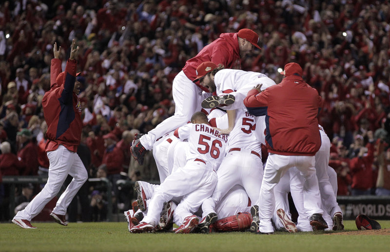 The Associated Press The St. Louis Cardinals pile on each other at Busch Stadium on Friday night after winning the World Series at home.