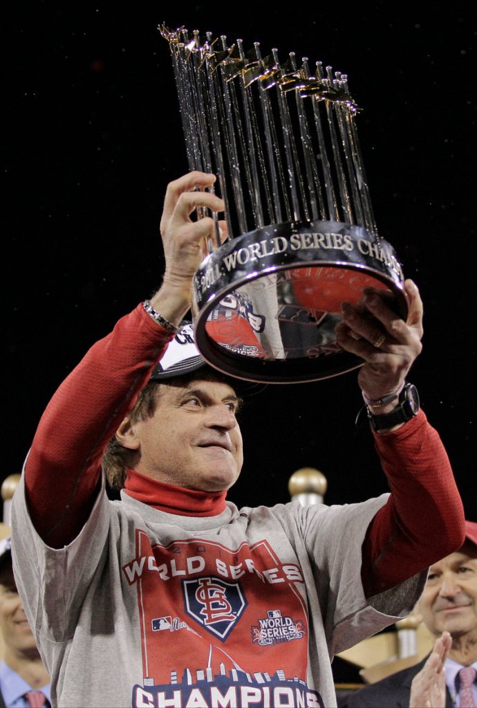 Manager Tony La Russa holds up the trophy after St. Louis beat Texas in Game 7 of the World Series on Friday.