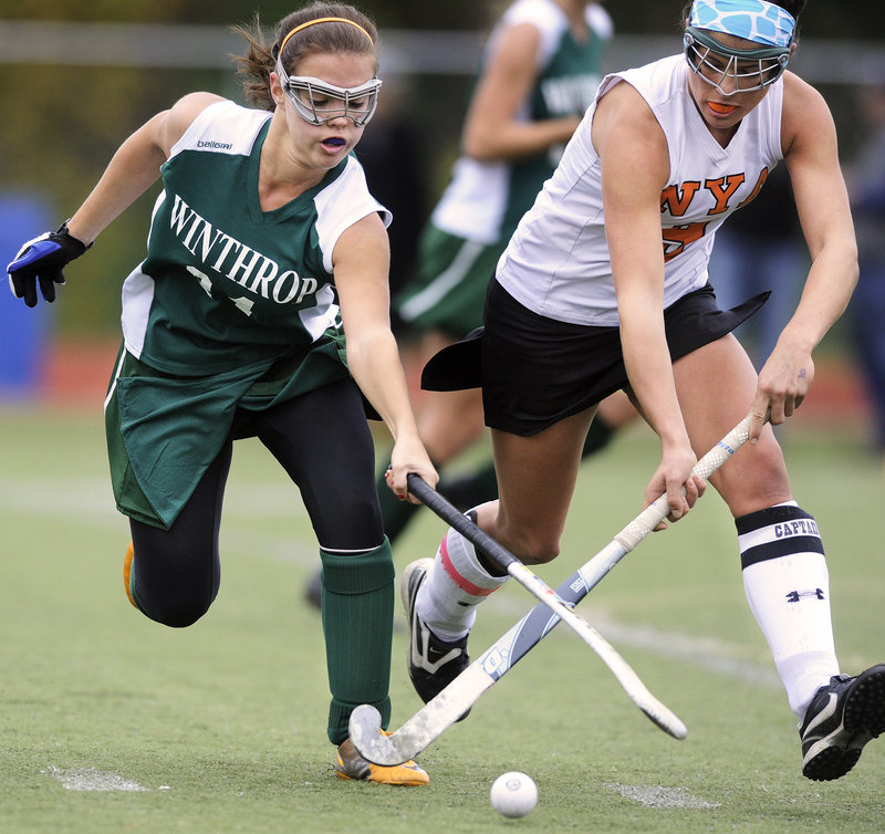 Elizabeth Glover, left, of Winthrop battles with NYA's Katie Millett during the Class C field hockey championship game Saturday at Yarmouth High. NYA won its second straight title, beating the Ramblers in penalty corners.