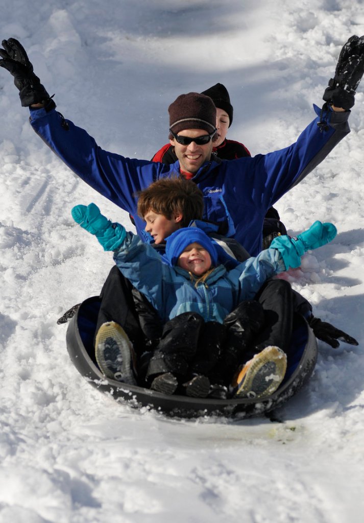 Jeff Hanselmann makes the best of the weekend snowfall at Gowen Park in Sanford with his daughter Caiti, 5, son Stephen, 8, and, at rear, friend Peter Nolin, 10, all of Springvale.