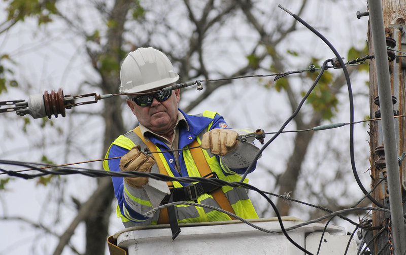 Guy Munn of the Canadian company O'Donnell Line & Electric works to restore power on Dyer Street in Saco on Sunday after a transformer was damaged by a falling tree, causing power outages in the area.