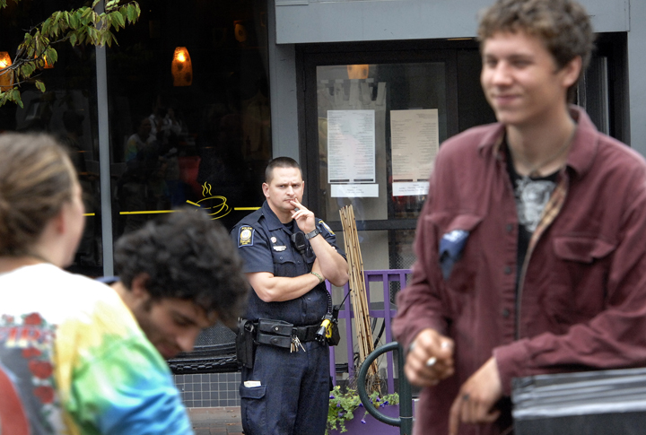 Portland Police Officer Gavin Hillard keeps an eye on demonstrators in Monument Square this morning.