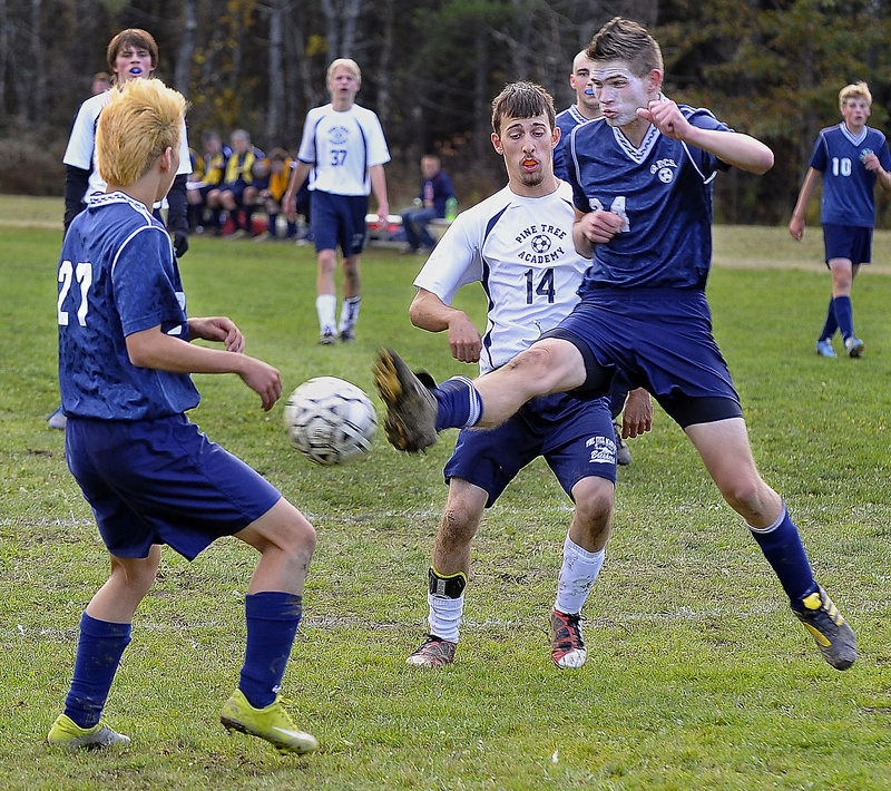 Than Peterson of Greater Portland Christian kicks the ball away from Pine Tree Academy’s Joe Reed as Jam Jung, left, looks on during their Western Class D quarterfinal Wednesday in Freeport. Pine Tree won, 5-0.
