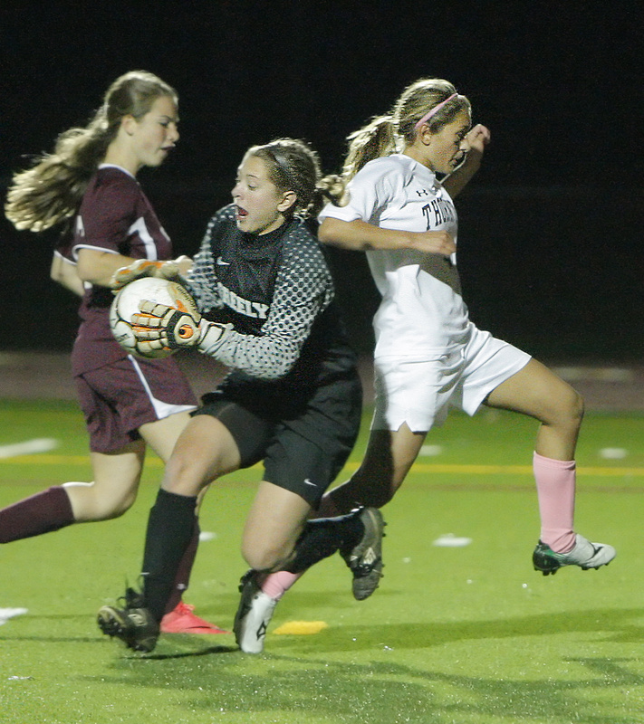 Greely keeper Caton Beaulieu hangs onto the ball as Thornton Academy’s Jaime Durie, right, charges by during a Western Class A quarterfinal Wednesday in Saco. Durie had two goals and an assist to lead the Trojans to a 3-2 victory.