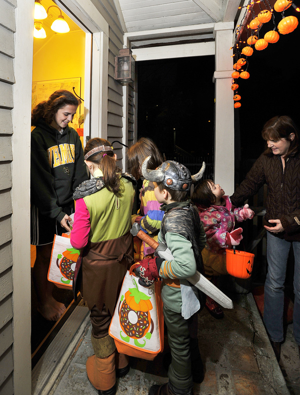 Caitlin Bucksbaum, 16, hands out treats to trick-or-treaters at the family home on Casco Terrace on Monday.