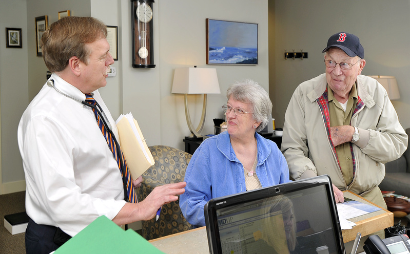 Dr. Philip Frederick chats informally with patients Gladys and Bradley Curtis of Freeport at his office in Yarmouth as they make their appointments for the next visit. Frederick is the first Maine physician to join MDVIP, a Florida-based company with a network of about 500 concierge medical practices.