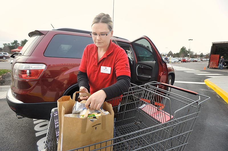 Photo by John Ewing/staff photographer... Tuesday, November 22, 2011. Hannaford's is launching a new service, Hannaford to Go, which allows shoppers to order groceries online and then pick their completed order at the store and into their car. Hannaford associate Nerissa Forbes loads groceries into Hannaford to Go customer Angela Libby's car at the North Windham store.