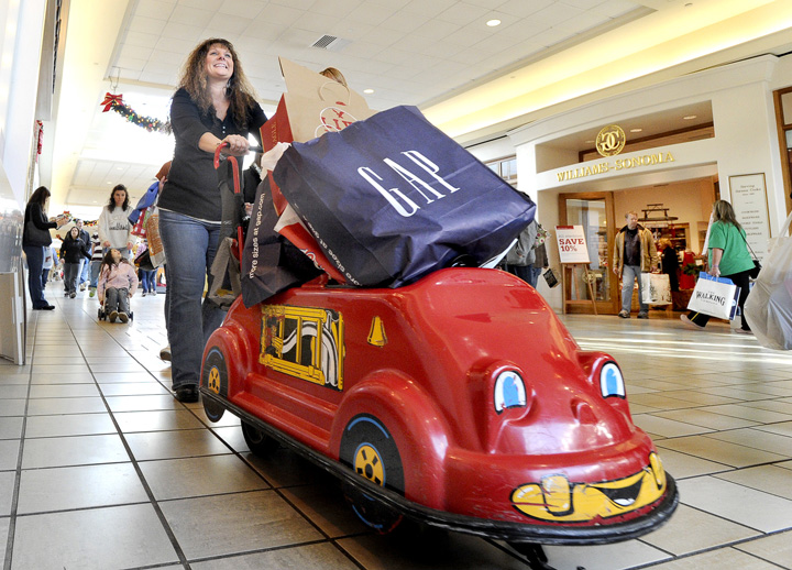 Carrie Campbell from Skowhegan pushes a loaded kiddie cart as she navigates among Black Friday shoppers at the Maine Mall in South Portland today.