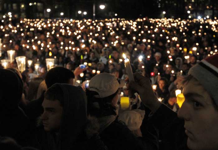 People hold candles during a candlelight vigil in front of the Old Main building on the Penn State Campus Friday, Nov. 11, 2011 in State College, Pa. The vigil is being held in support of the alleged victims of a child sex abuse scandal involving a former assistant coach. (AP Photo/Alex Brandon)