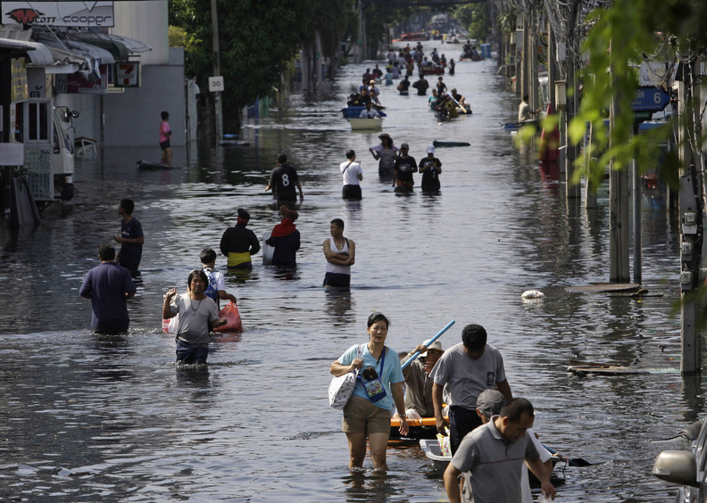 Thai residents carry their belongings as they move to higher ground Monday in flood-plagued Bangkok. The country has suffered its worst flooding in five decades, triggered by unusually heavy monsoon rains that began in July. A draft report by climate scientists warns that weather extremes will intensify as global warming worsens.