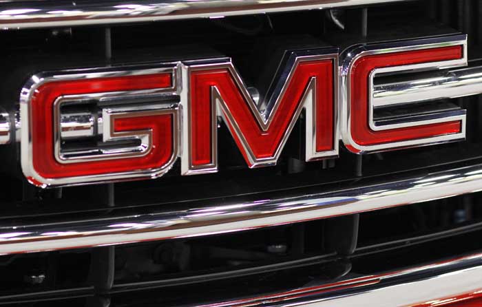 This Oct. 28, 2011 photo, shows the GMC nameplate on the grille of a 2012 GMC Sierra at the 41st annual South Florida International Auto Show, in Miami Beach, Fla. General Motors said Wednesday, Nov. 9, 2011, it earned $1.7 billion in the third quarter, down 15 percent from a year earlier. (AP Photo/Lynne Sladky)