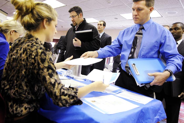 Clarence Turner of Little Canada, Minn., hands in his resume at the Minneapolis Career Fair held in Bloomington, Minn., recently.