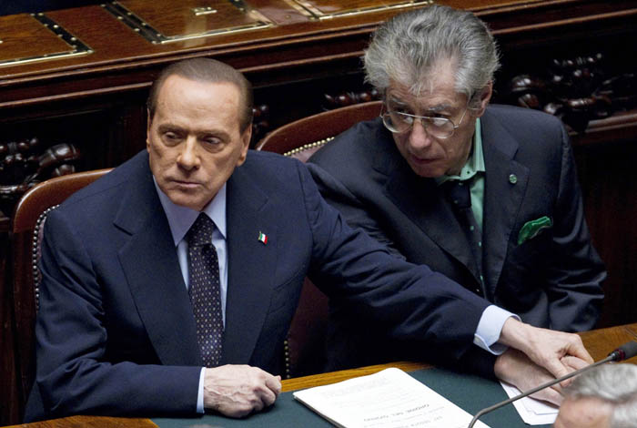 Italian Premier Silvio Berlusconi, left, holds the hand of Reforms Minister Umberto Bossi during a voting session at the Lower Chamber, in Rome, today. Berlusconi won a much-watched vote, but the result laid bare his lack of support in Parliament as financial pressure from the eurozone debt crisis pummeled Italy.